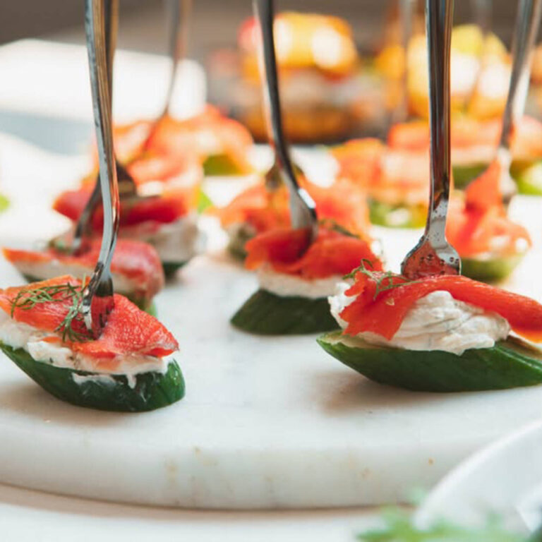 Smoked salmon and cream cheese on cucumber rounds with dill, served on silver tasting forks