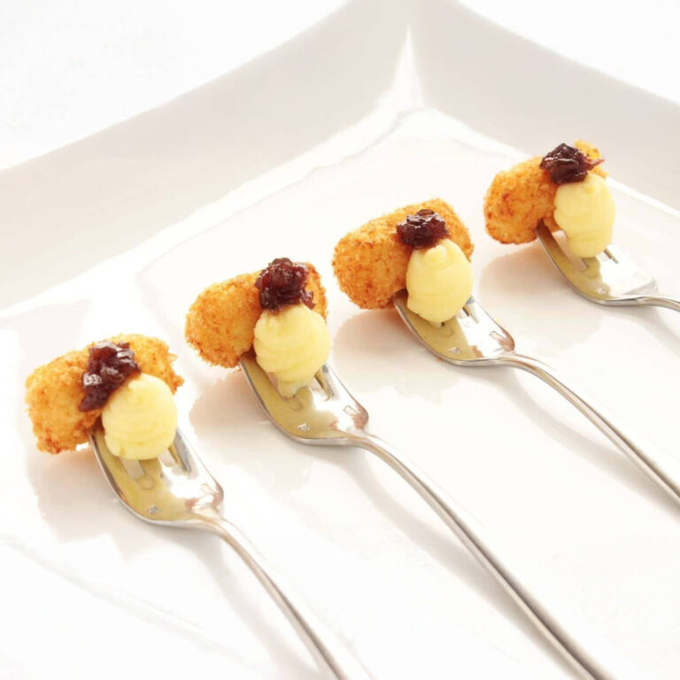 Breaded croquettes with cranberry relish and whipped potato on forks