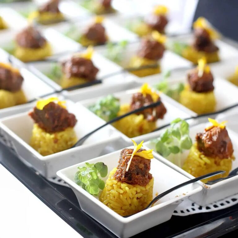 Canapé tasting bites with saffron rice, beef topping, and microgreens on tiered wire display racks