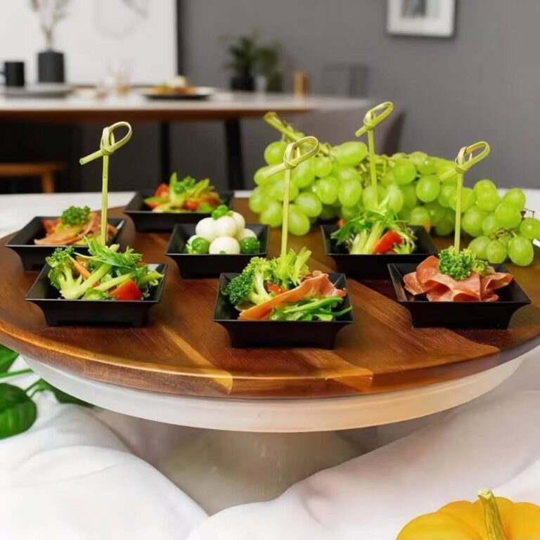 Vegetable and prosciutto tasting bites with bamboo knot picks and grapes on a wooden lazy susan board