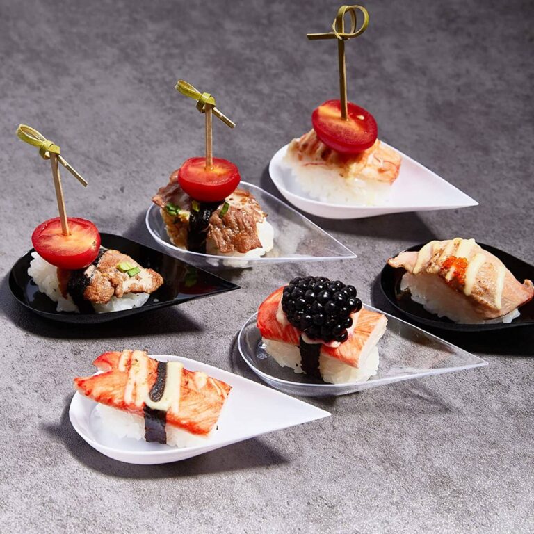 Assorted sushi nigiri bites with tuna, salmon, and shrimp topped with cherry tomato skewers on tasting spoons