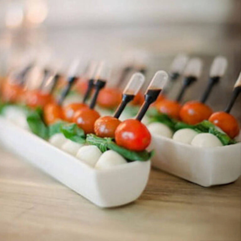 Caprese skewers with cherry tomato, mozzarella, and basil with balsamic sauce pipettes in white dishes