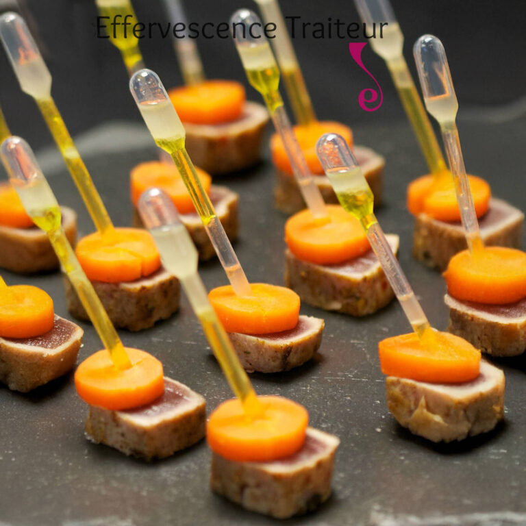 Seared tuna and carrot bites with citrus sauce pipettes on a dark tray