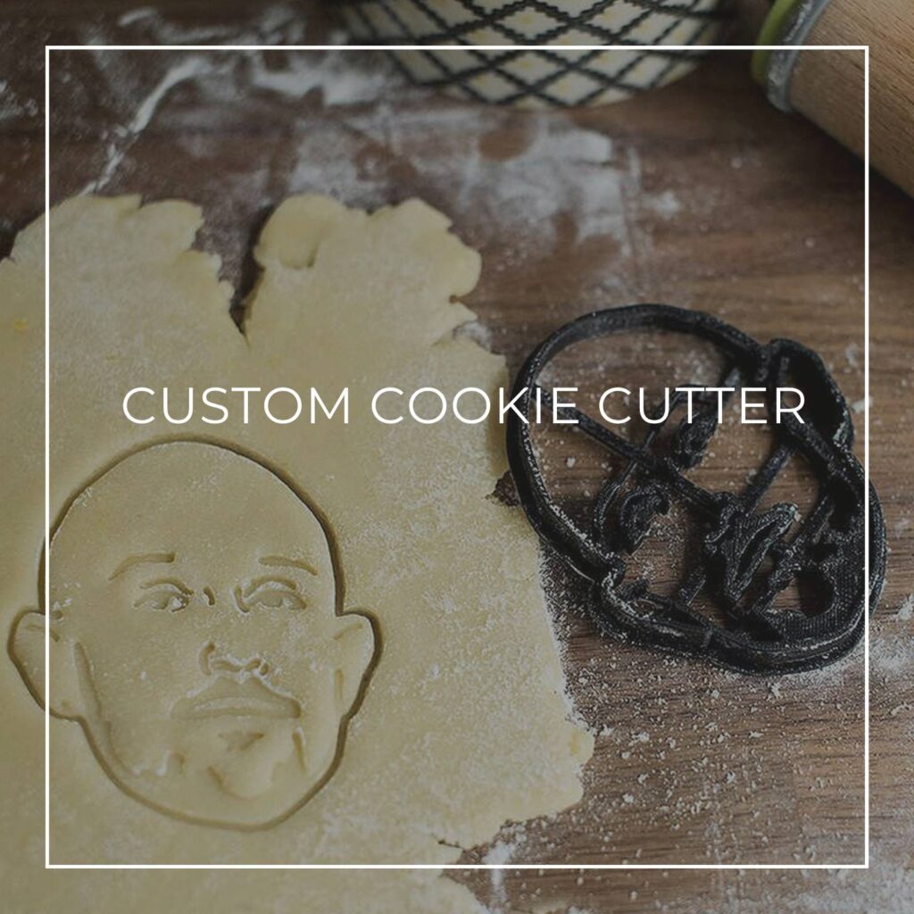 personalized custom cookie cutter of a bald man's face pressed into rolled out dough