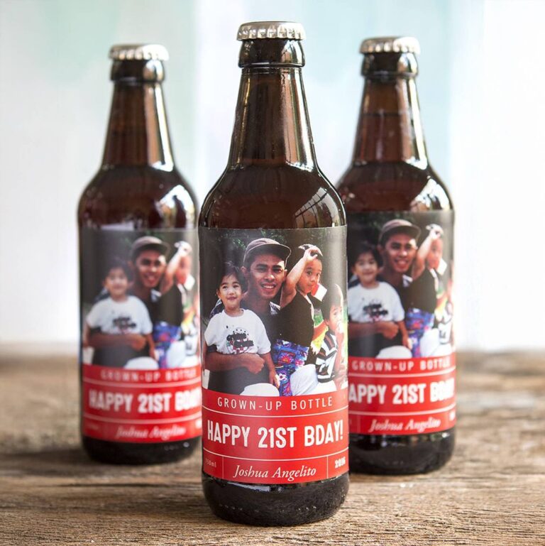 Three beer bottles with red "Grown-Up Bottle, Happy 21st BDAY!" labels printed with the same family photo and "Joshua Angelito, 2016"