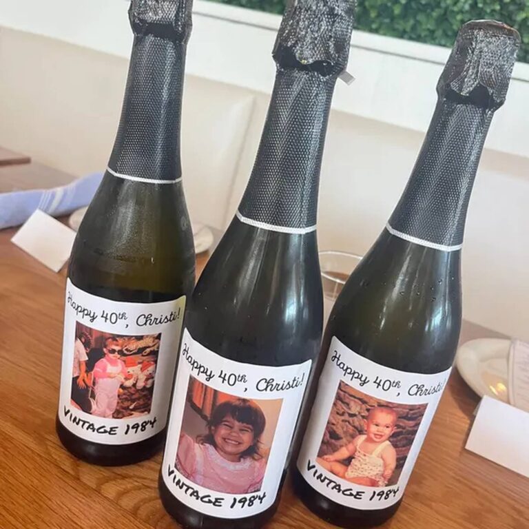Three champagne bottles with “Happy 40th, Christi! Vintage 1984” labels, each printed with a different childhood photo of the same person