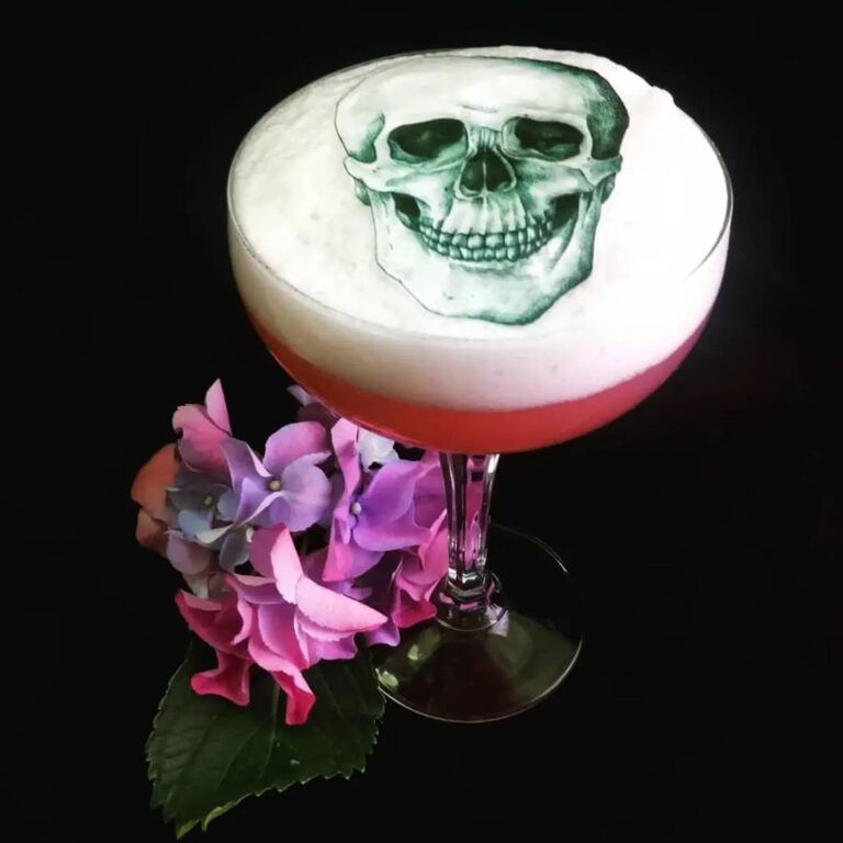 Edible skull topper on a foam-topped cocktail with fresh hydrangeas