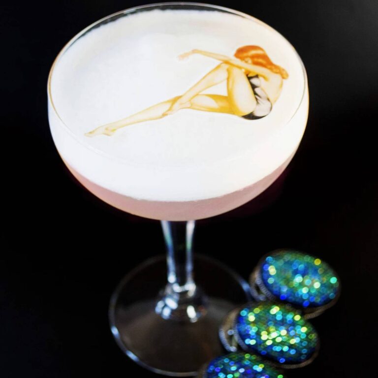 Decorative illustrated topper on a foam-topped cocktail