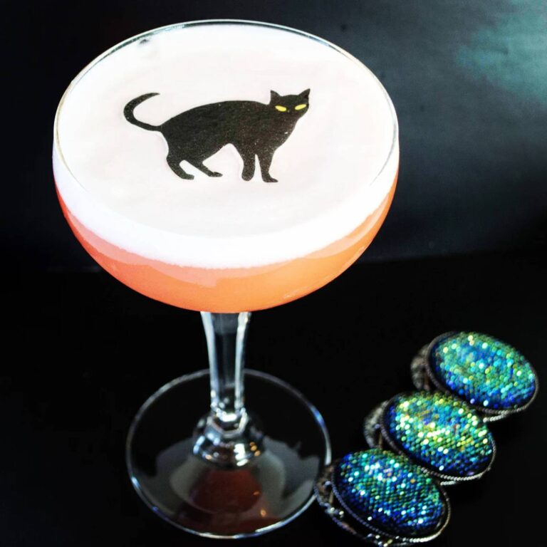 Edible black cat topper on a Halloween-themed cocktail