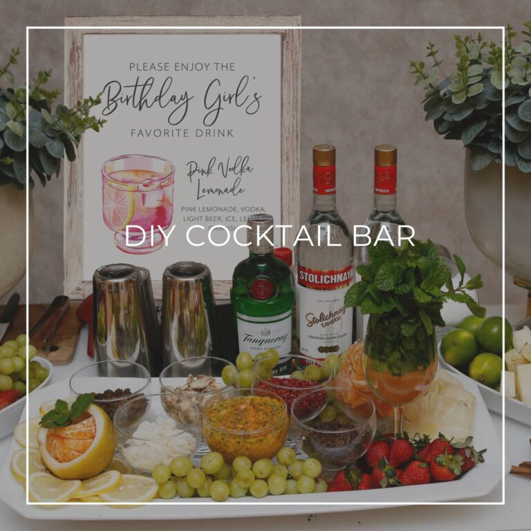 DIY cocktail bar with liquor, ingredients, and a cocktail recipe sign for party guests to make their own drink