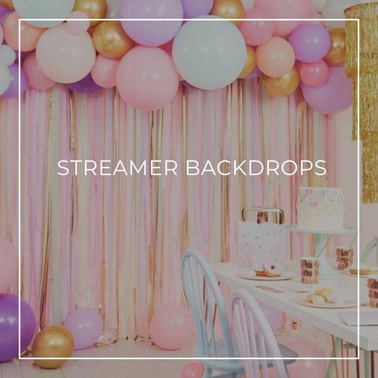 pastel colored streamer backdrop to a party table with balloons above