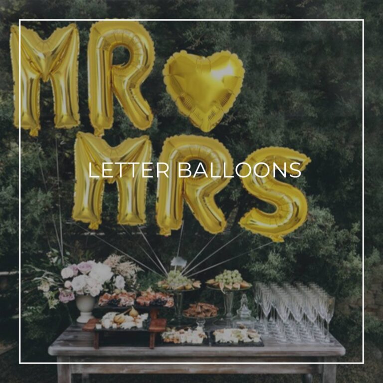 surprise party giant letter balloons spelling MARY above a party food table