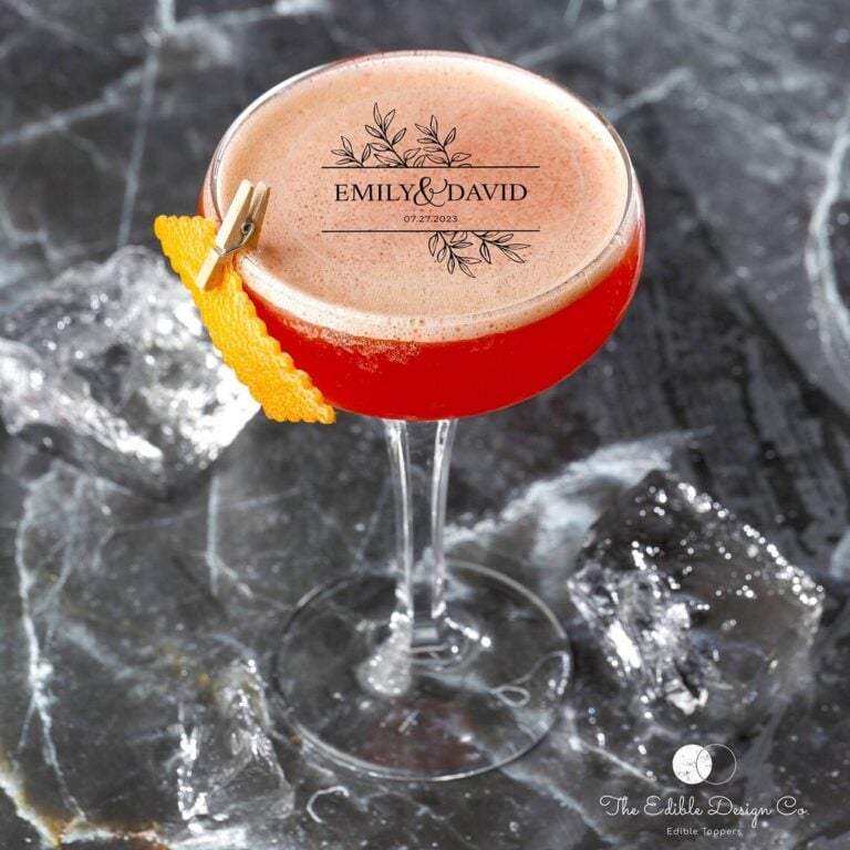Edible text topper reading "Emily & David" with a leaf design on a wedding cocktail