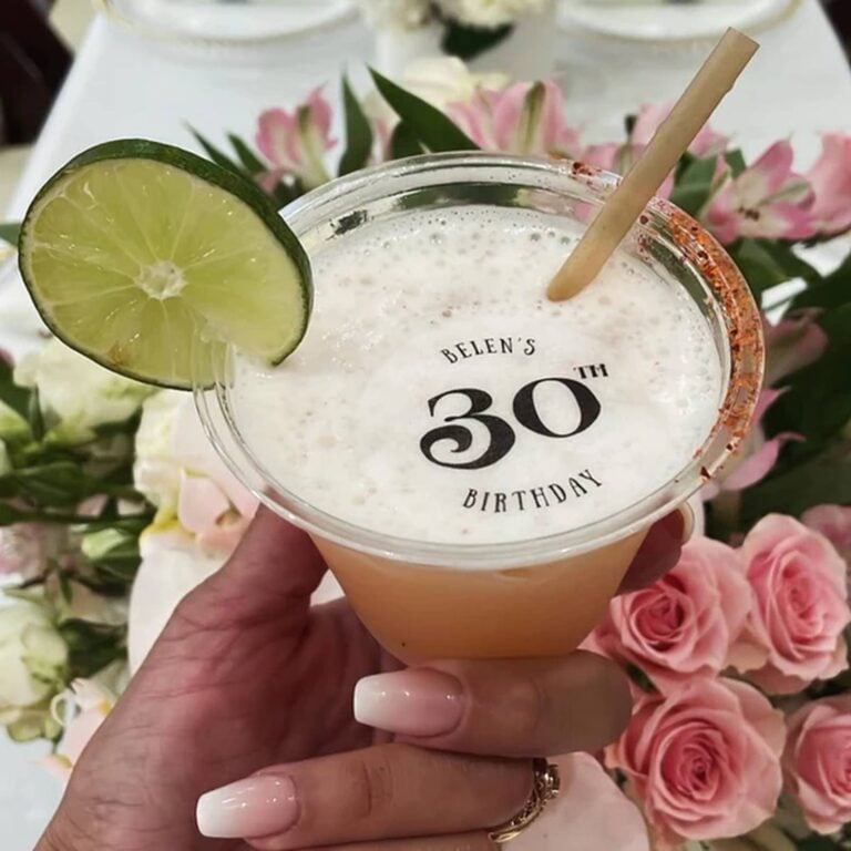 Edible numeral topper reading "Belen's 30th Birthday" on a cocktail with a lime garnish