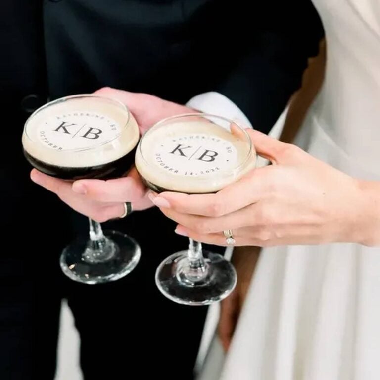 Edible monogram topper reading "K/B" on a foam-topped wedding cocktail