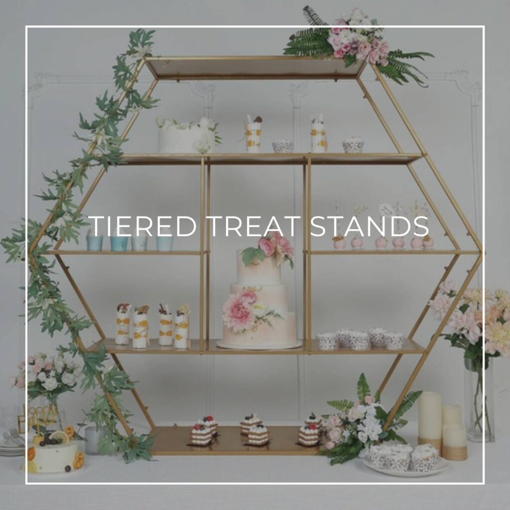 hexagon shaped tiered treat stand filled with desserts and treats on a wedding dessert table
