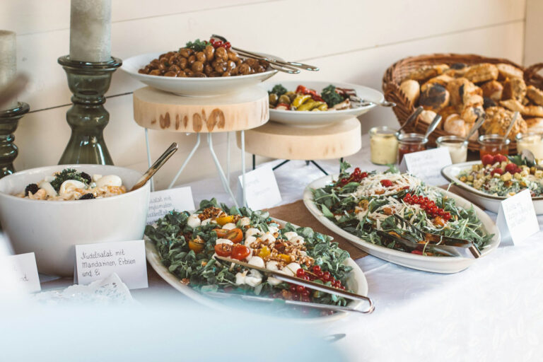 serving platters and plates of food laid out on a traditional party buffet table