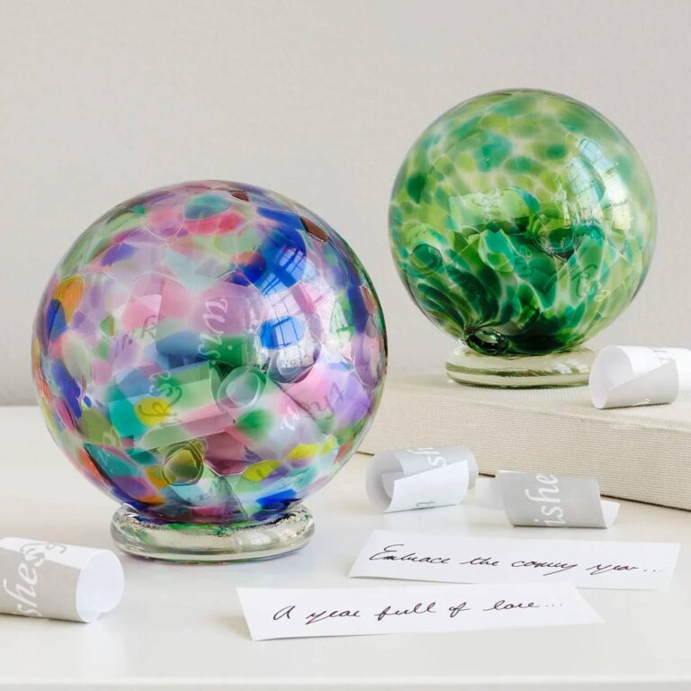 Multicolor and green hand-blown glass wishing balls with rolled paper wishes and handwritten wish notes