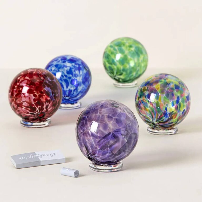 Five glass wishing balls in red, blue, green, purple and multicolor arranged together with a wishes and thanks card